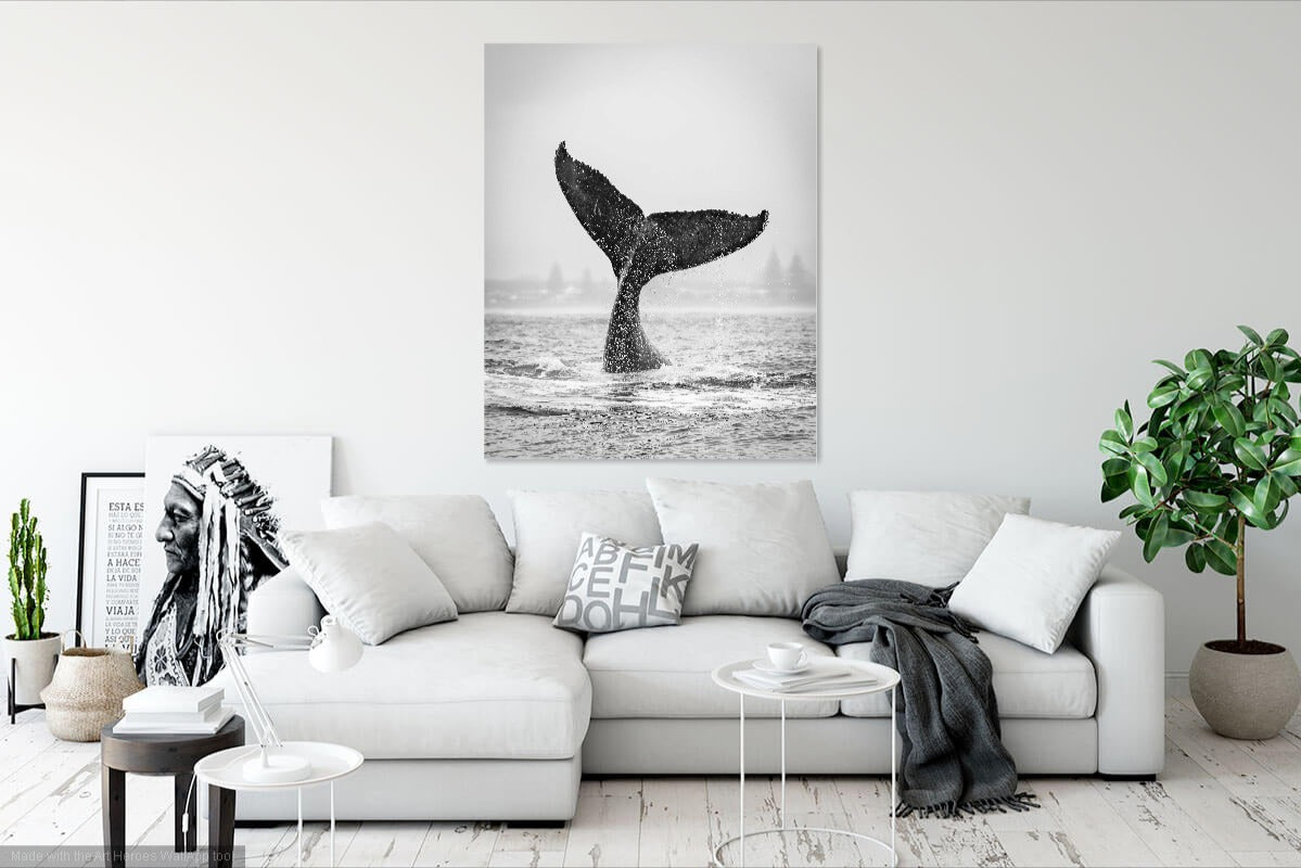 Living room with a white sofa, decorative pillows, and a whale tail art print on the wall.